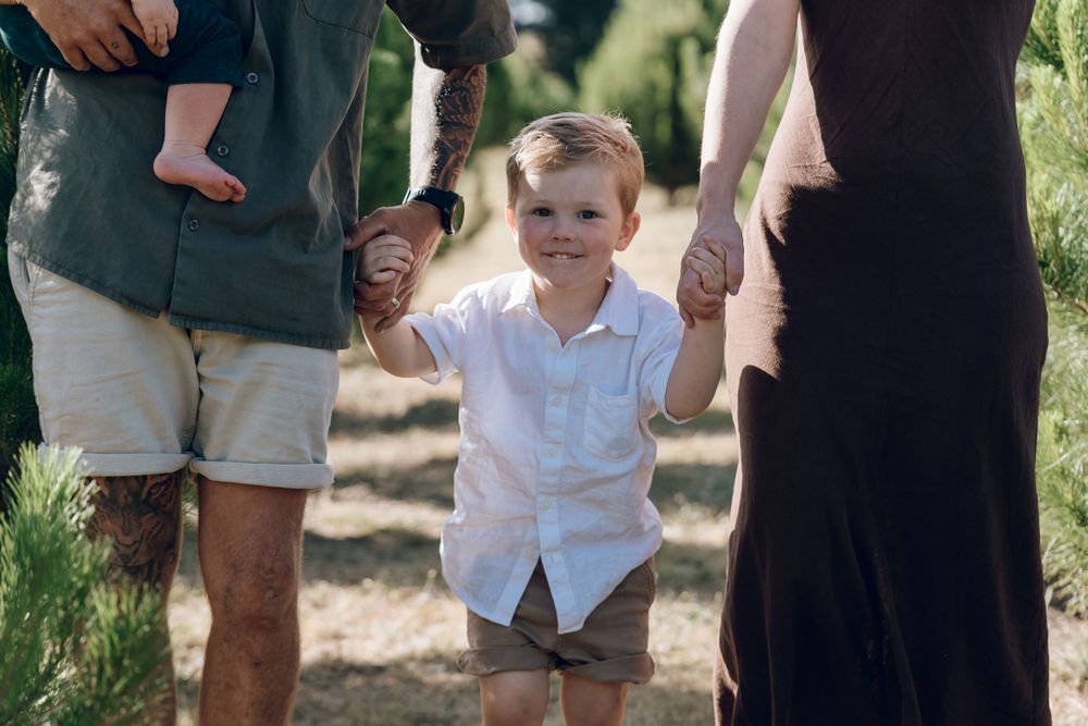Family members strolling together on grass path during outdoor photo session.