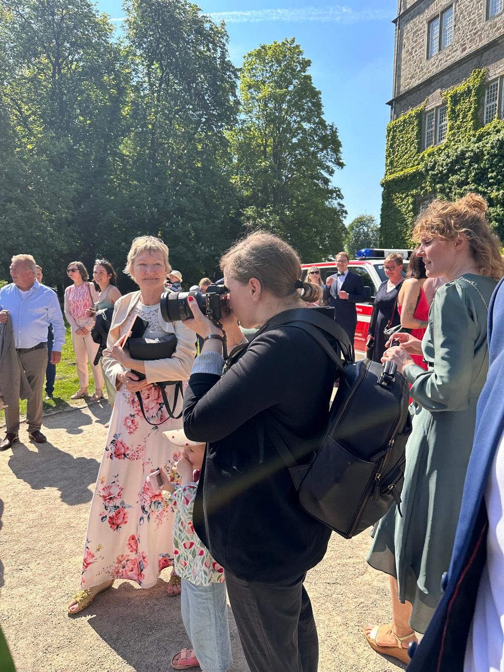 Fotografin inmitten von Hochzeitsgästen auf einer Hochzeit im Schloss in Wolfsburg.