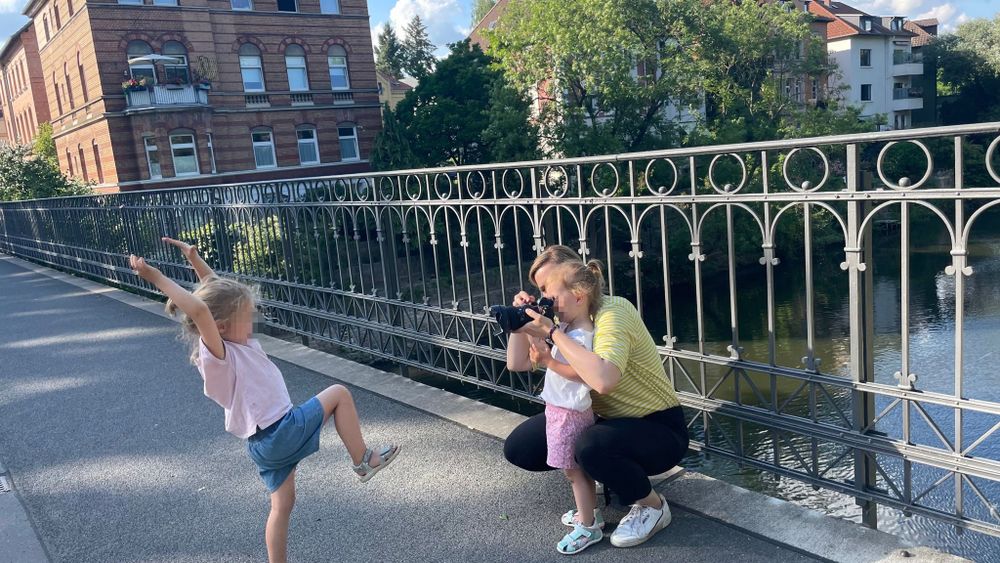 Fotografin mit zwei Kindern auf einer Brücke in Braunschweig an einem sonnigen Tag für ein Familienfotoshooting.