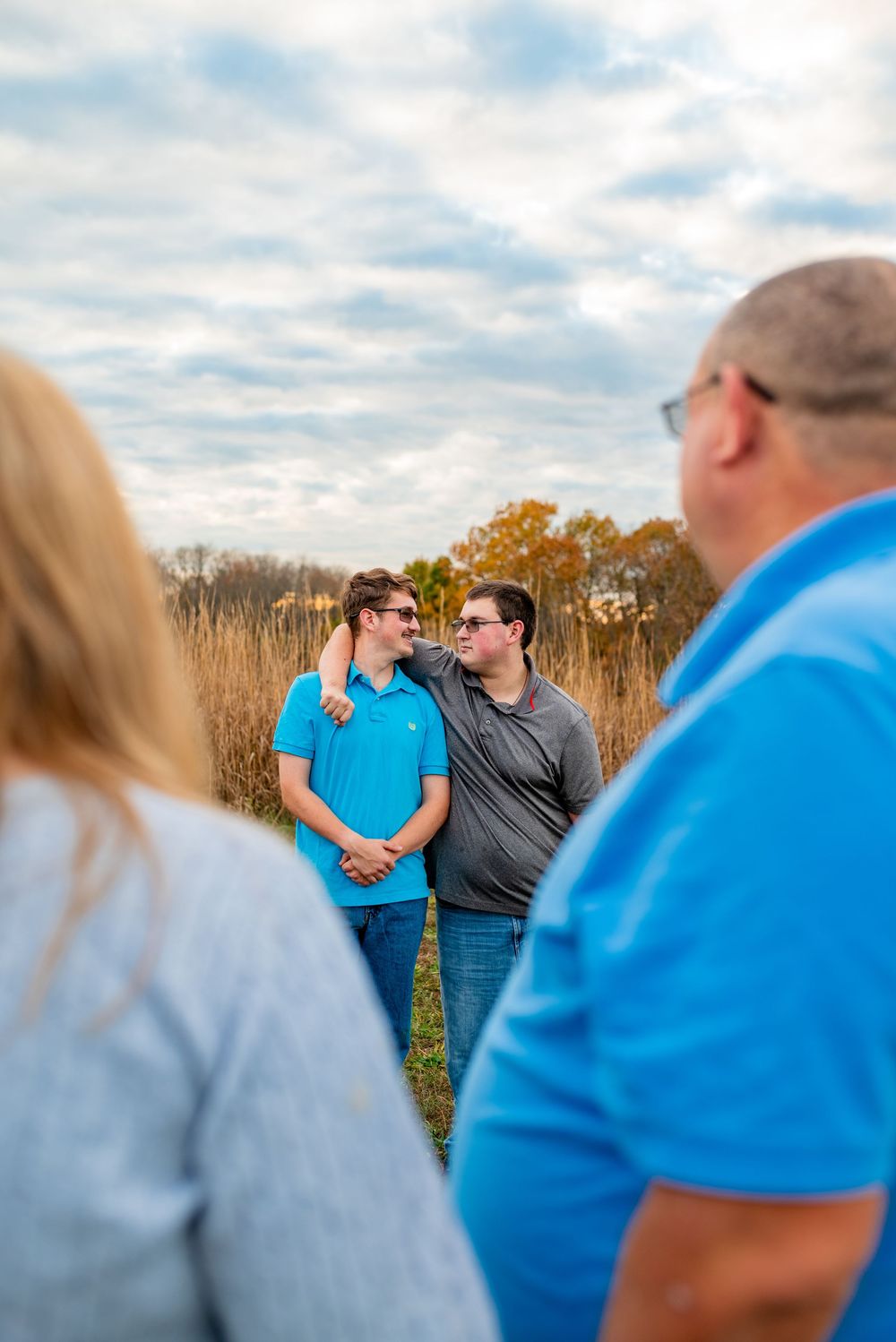 A playful outdoor family photoshoot sequence showing candid interaction against an autumn field backdrop.