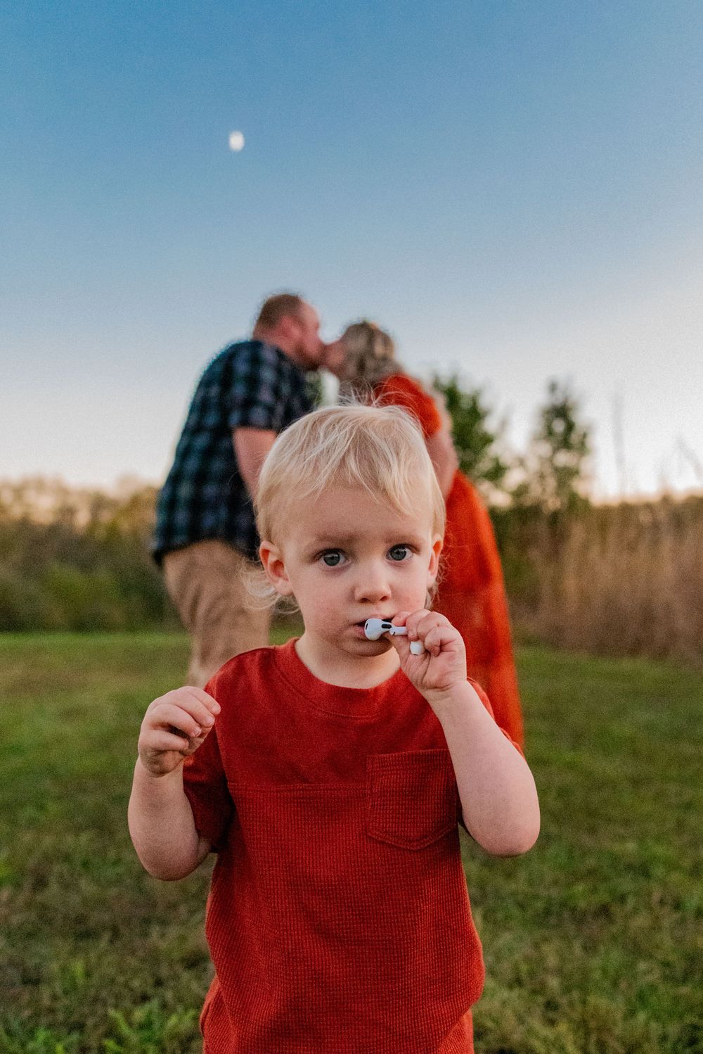 Close-up shots of a toddler in a red shirt playing outdoors.