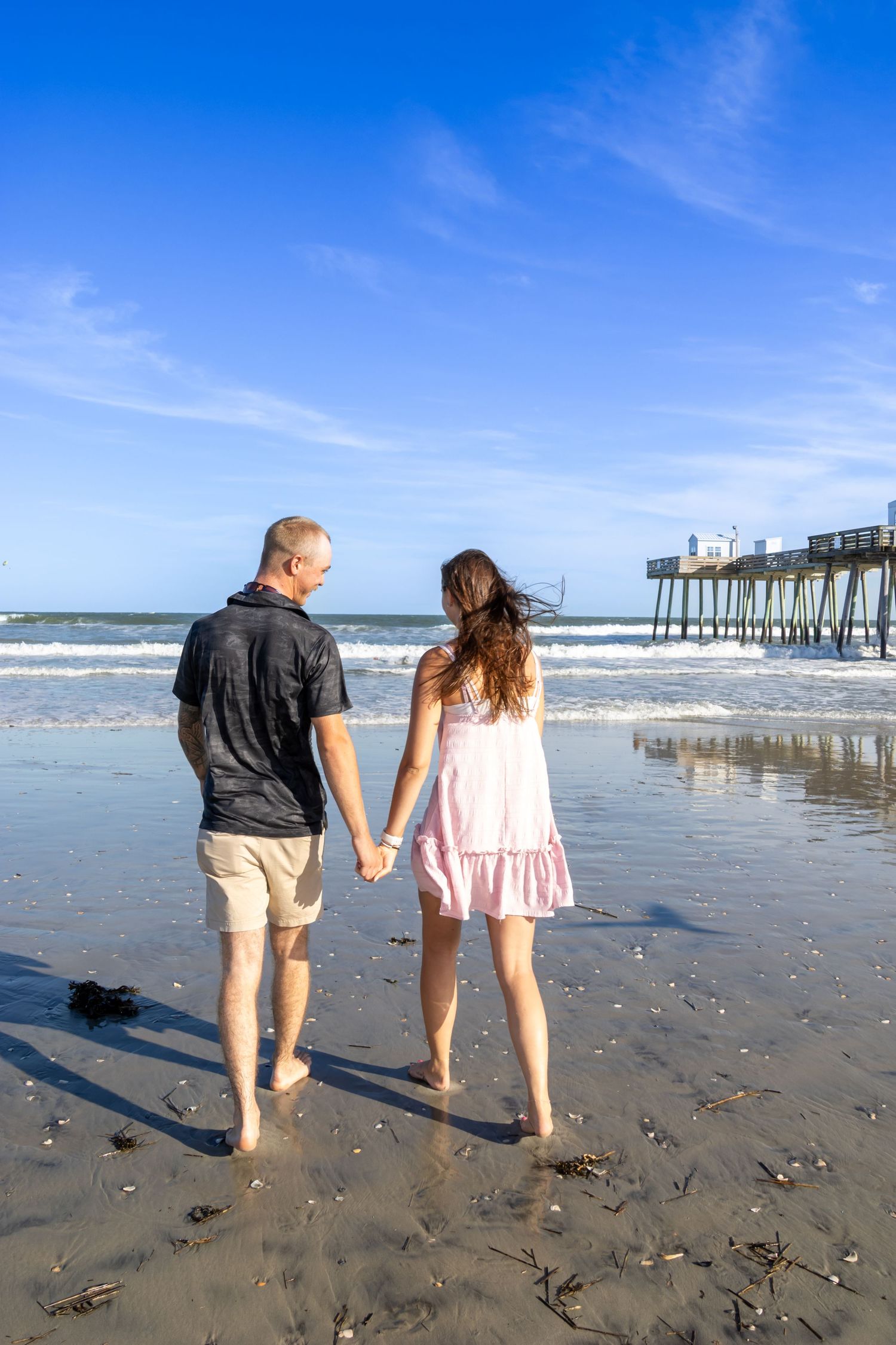 young couple walking towards the ocean after becoming engaged. Salem and Gloucester County Photographer