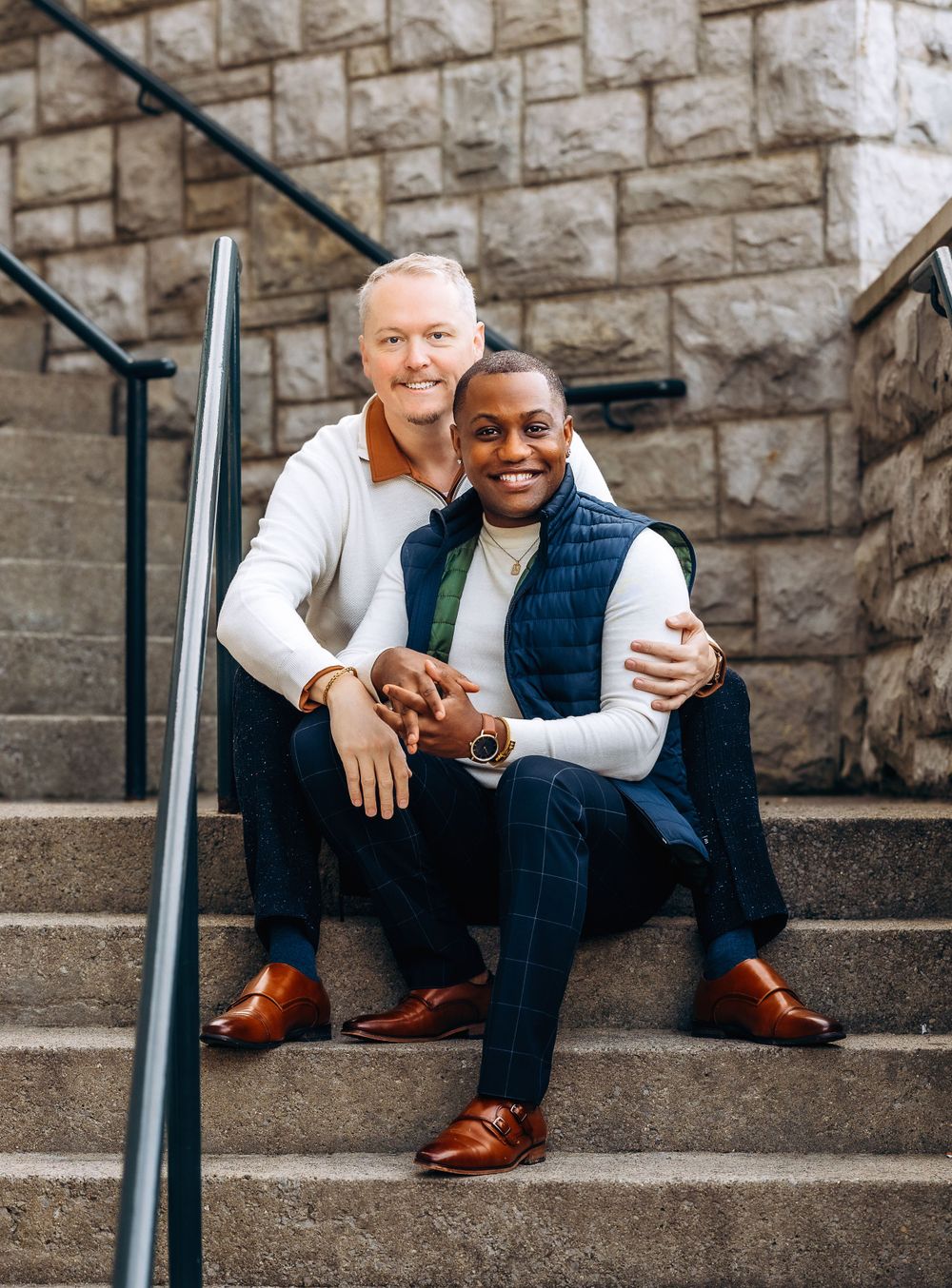 Couple sitting together on stone steps sharing an intimate moment and warm smiles.