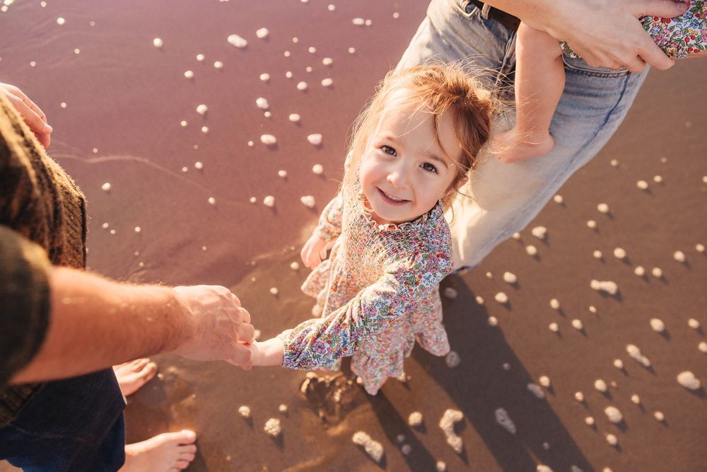 Carefree play moment at beach with water splashing and joyful expressions.