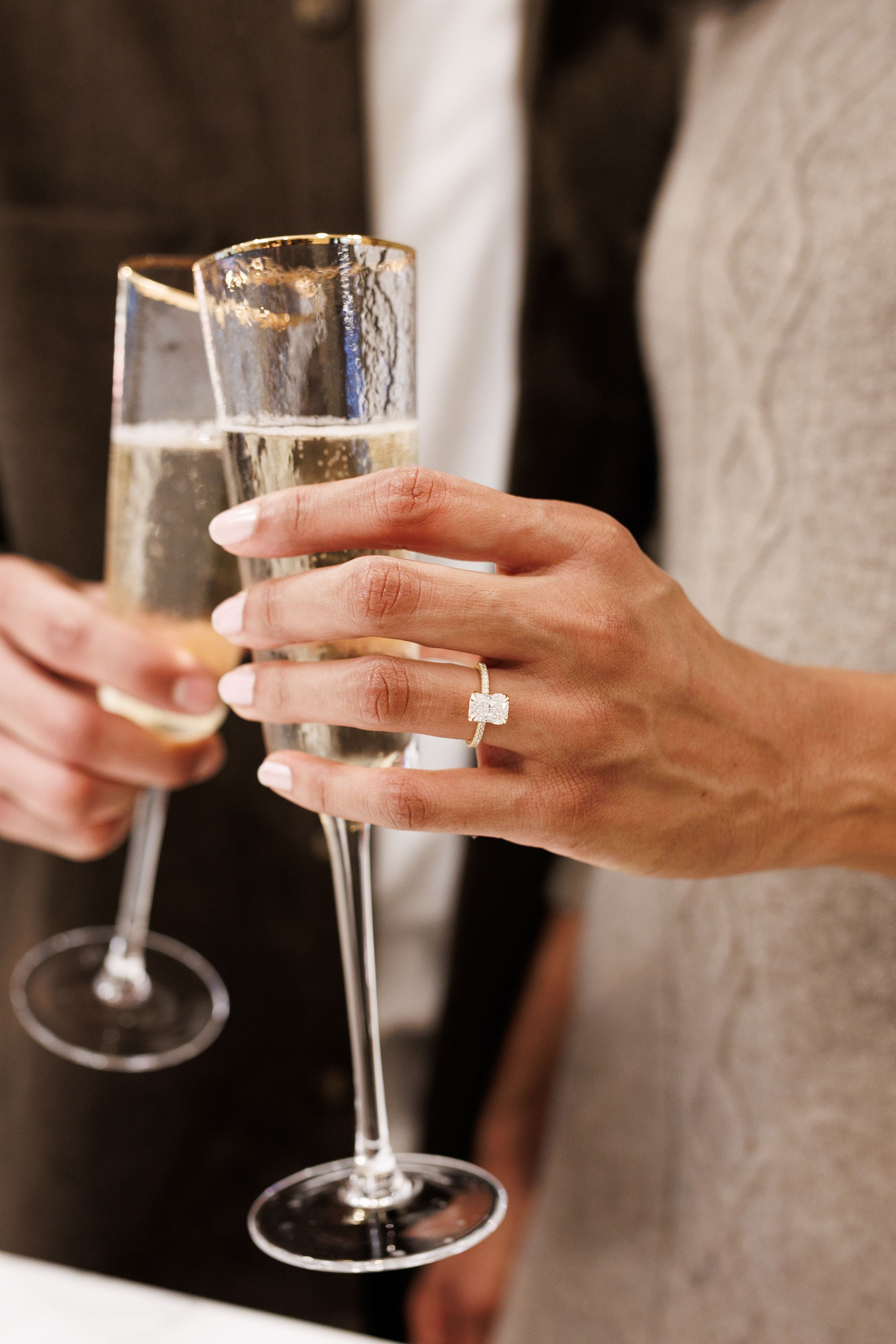engaged couple toasting with wine glasses during romantic engagement session
