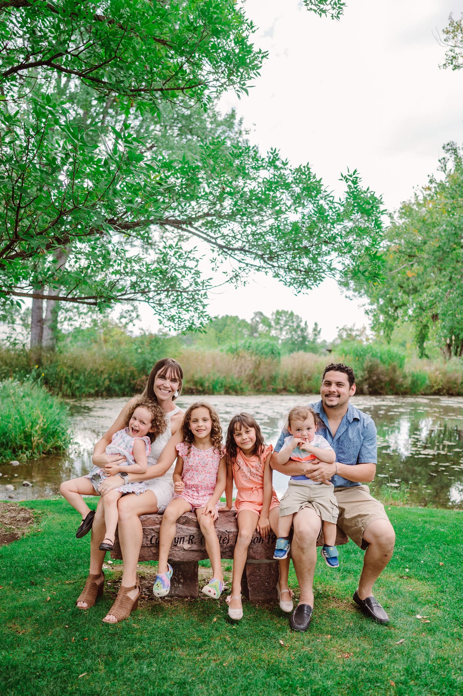 family of 6 posed on a park bench in Hudson Gardens in Littleton Colorado