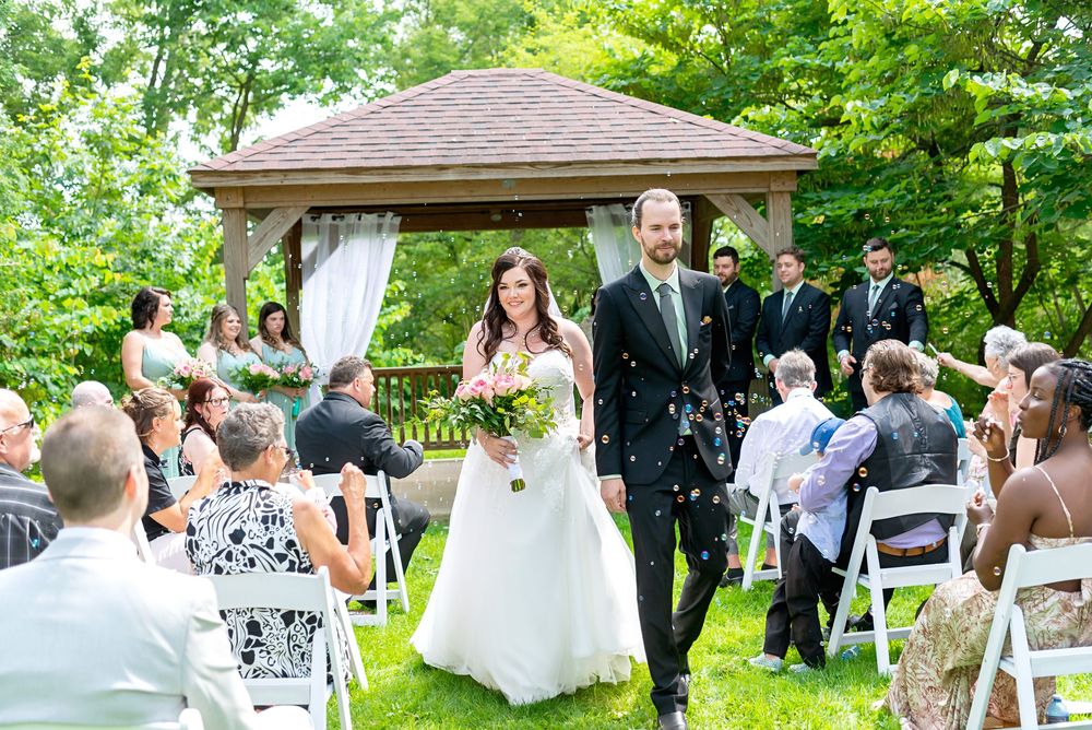 Outdoor wedding ceremony setup with white chairs and guests in a lush garden setting at Elsie Perrin Williams Estate in London.