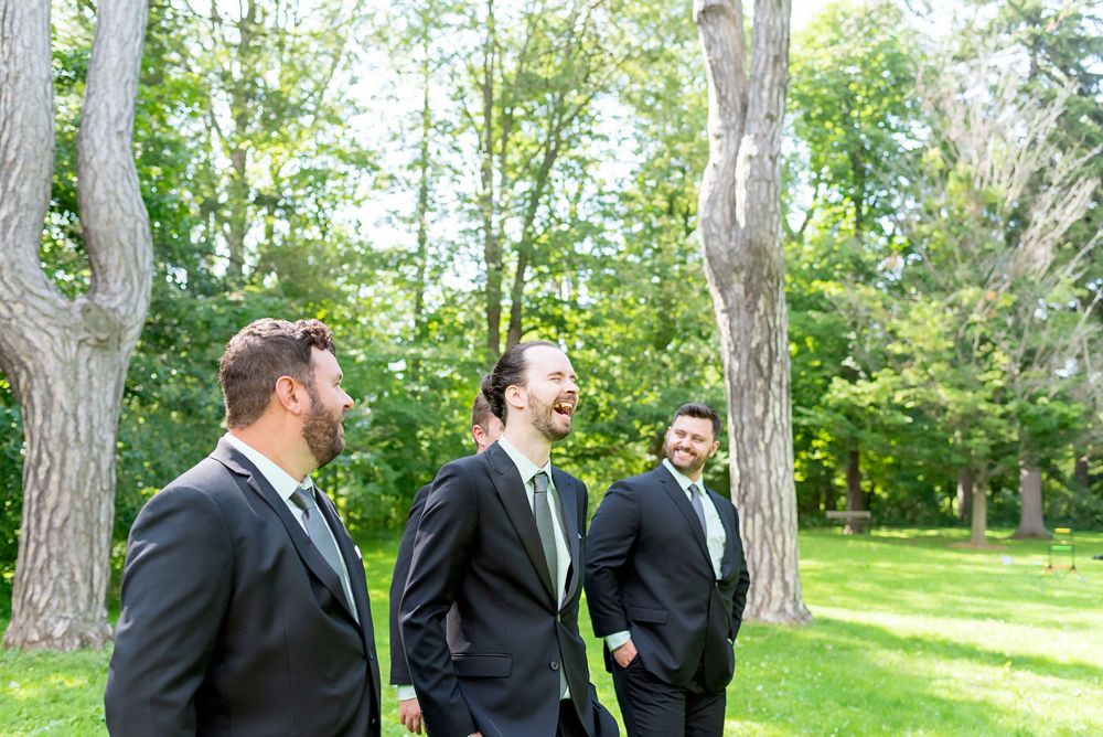 Wedding party members pose outdoors among tall trees at Elsie Perrin Williams Estate in London.