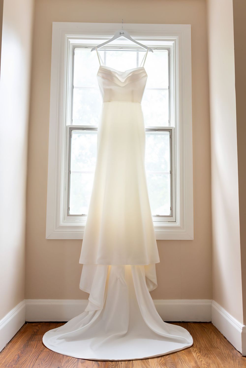 White wedding dress displayed in natural light through multiple window frames in London Ontario