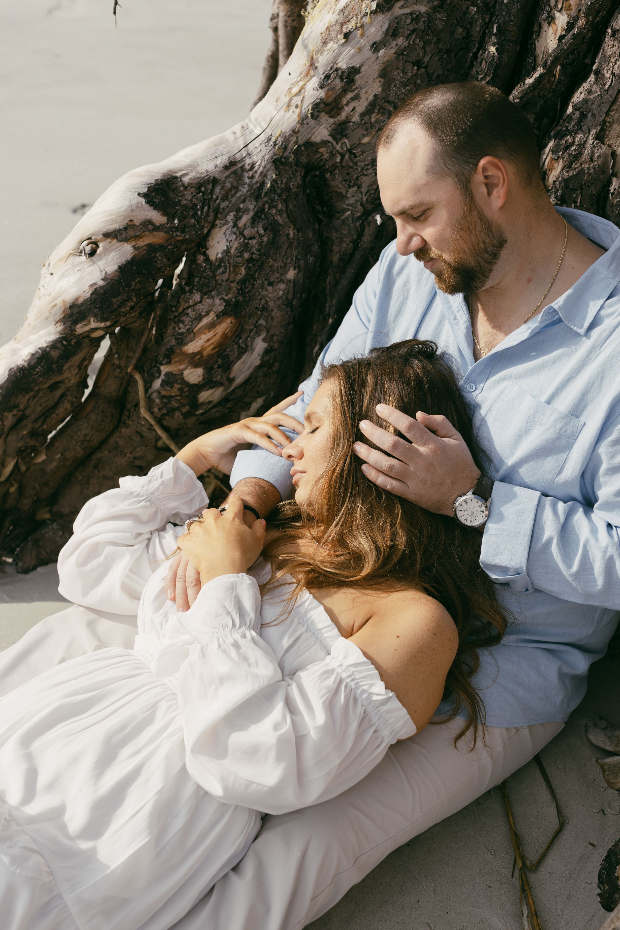 Romantic couple from North Carolina in engagement session sharing a kiss surrounded by boneyard beach in Hunting Island, South Carolina.