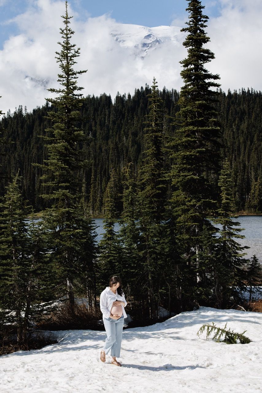 Expecting mother posing in a pnw park with mountain mount rainier. Adventure and intimate maternity photography by Tim Neal.