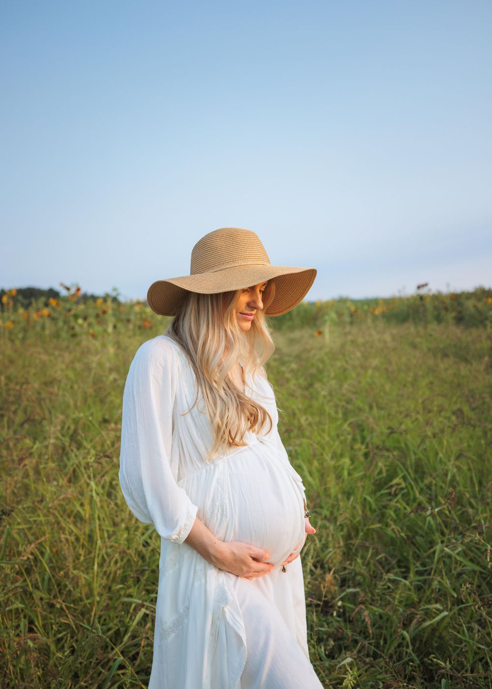 Expecting mother posing in a Snohomish field at sunset. Warm and intimate maternity photography by Tim Neal.