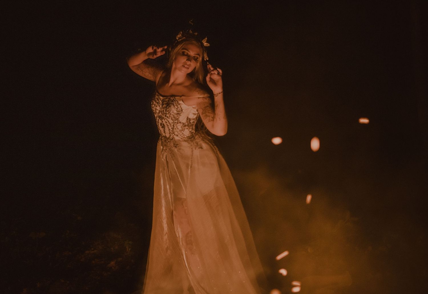 Bridal portrait around a fire. Stunning details in the wedding dress.