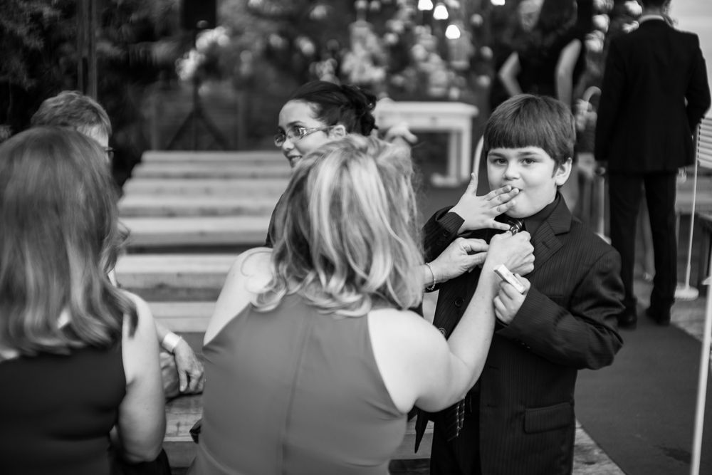 Black and white candid photo of wedding guests during outdoor celebration.