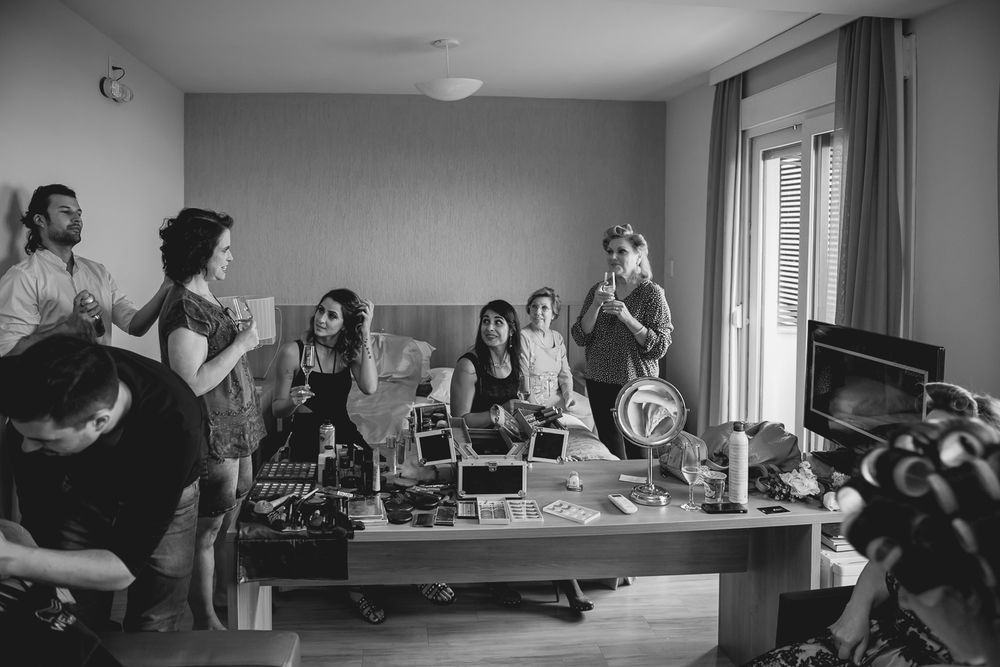 Black and white scene of a group gathered in a room with styling equipment and preparations.