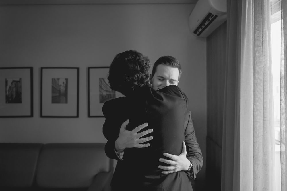Intimate black and white moment captured in a room with natural window light.