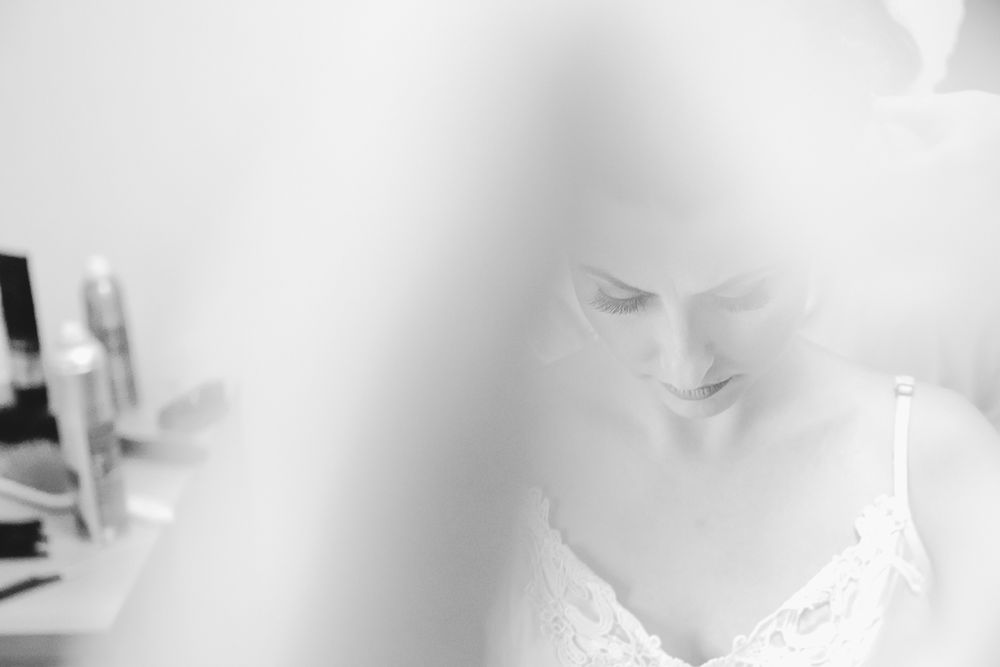 Soft focus close-up shot of delicate lace details in dreamy white lighting.