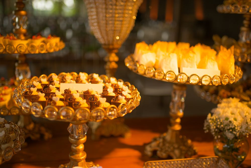 Elegant dessert display featuring illuminated pastries and treats on crystal pedestals.