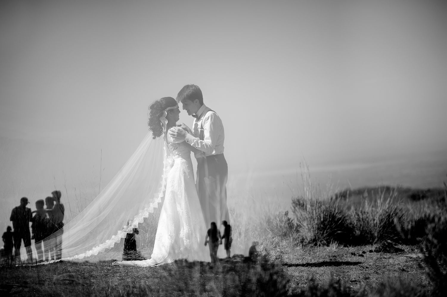 A romantic wedding moment captured against a misty mountain backdrop.