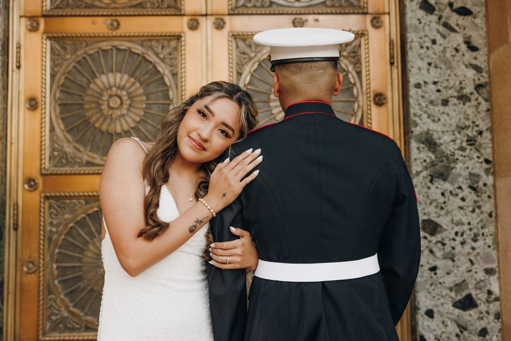 A bride and groom embrace in front of ornate wooden doors at a the Phoenix Courthouse.