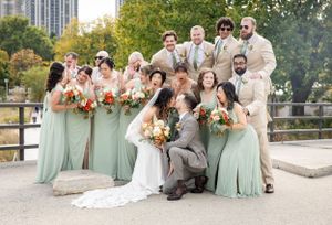 Close-up detail of bride's hand on groom's gray suit jacket showing tender embrace.