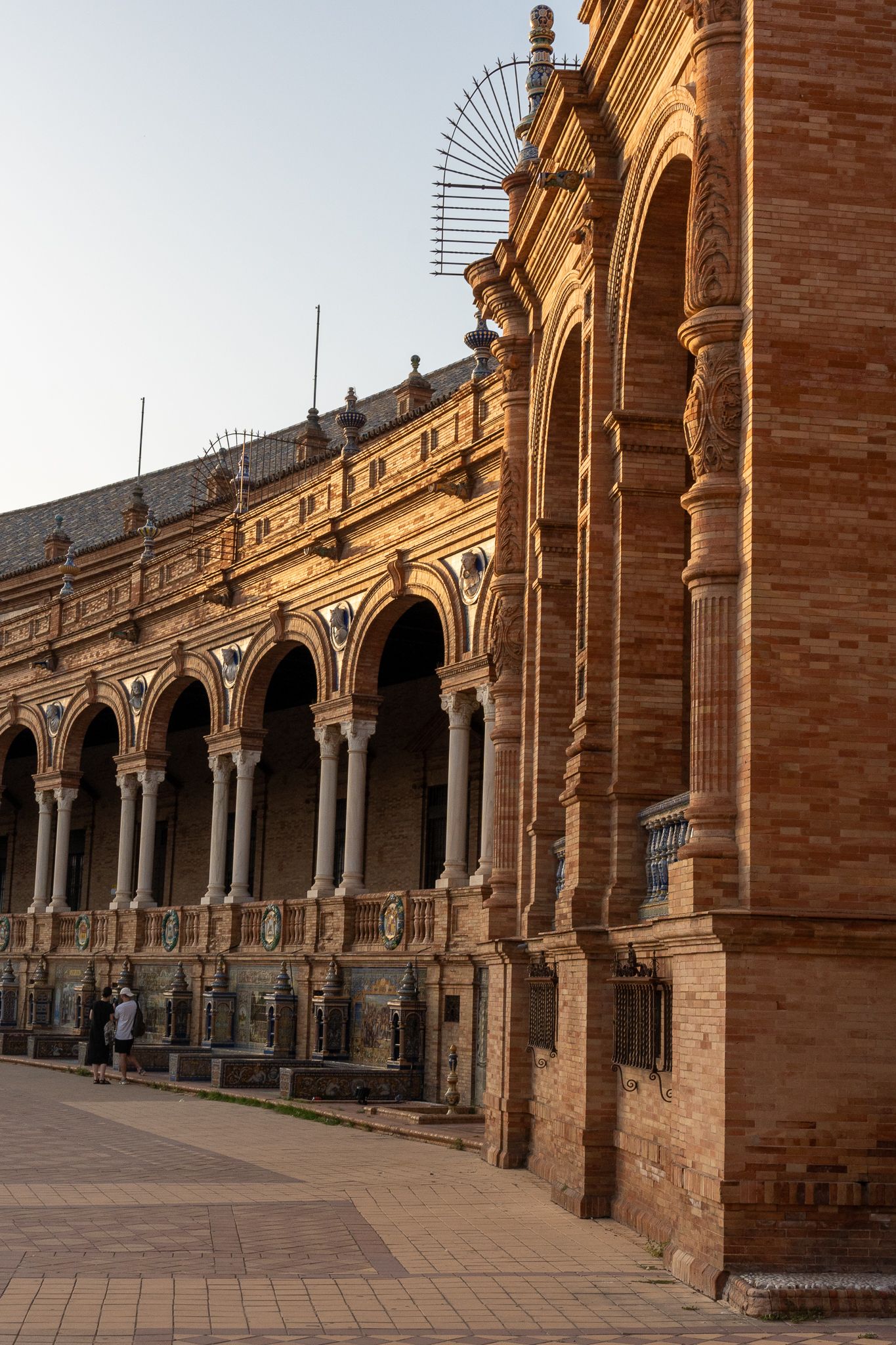 Historic arched colonnade with ornate Classical architecture at Plaza de España in Seville.