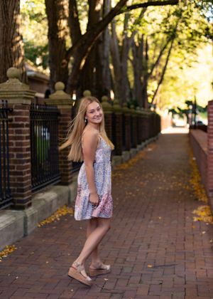 Fashion photography on a tree-lined brick pathway during golden hour.