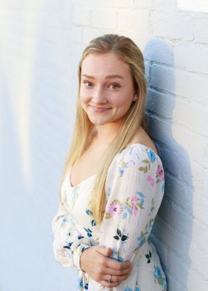 Portrait series featuring a floral print top with puff sleeves against a white wall.