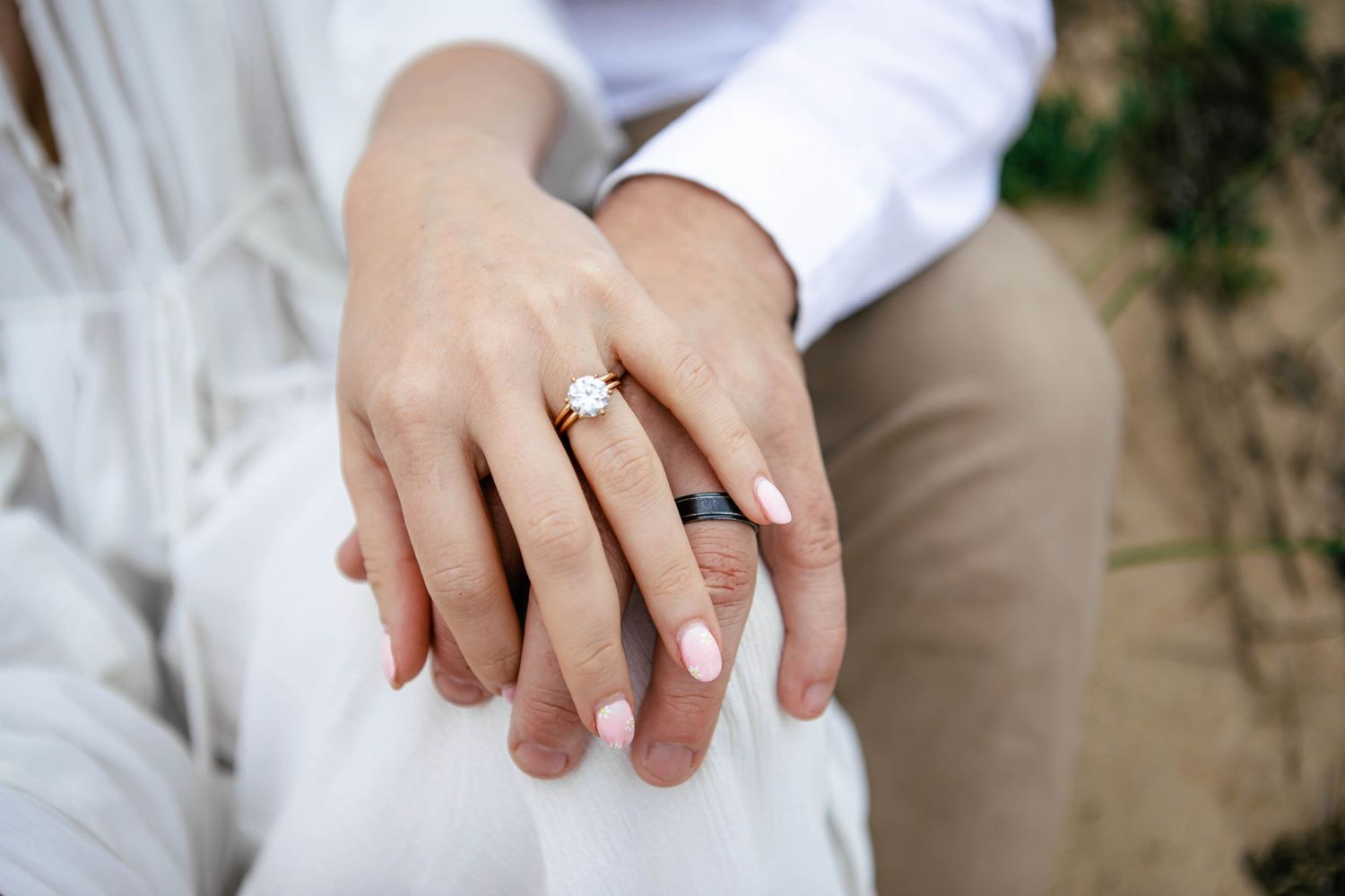 Close-up shots of engagement ring and hands against beach backdrop.