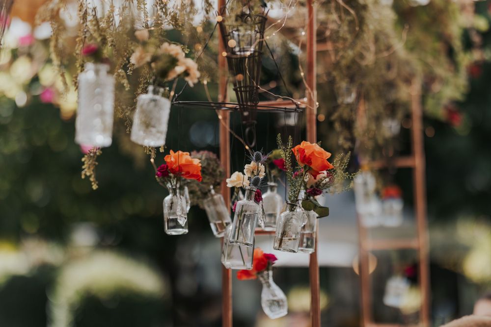 Hanging mason jar decorations with orange flowers create romantic outdoor wedding ambiance in New England.