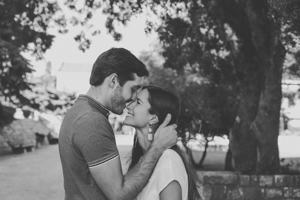 Black and white romantic photos of a couple sharing tender moments outdoors.