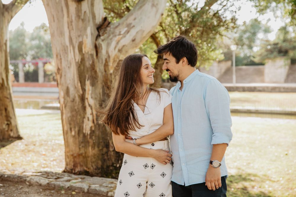 Natural outdoor portraits of a couple under large eucalyptus trees in a park setting.
