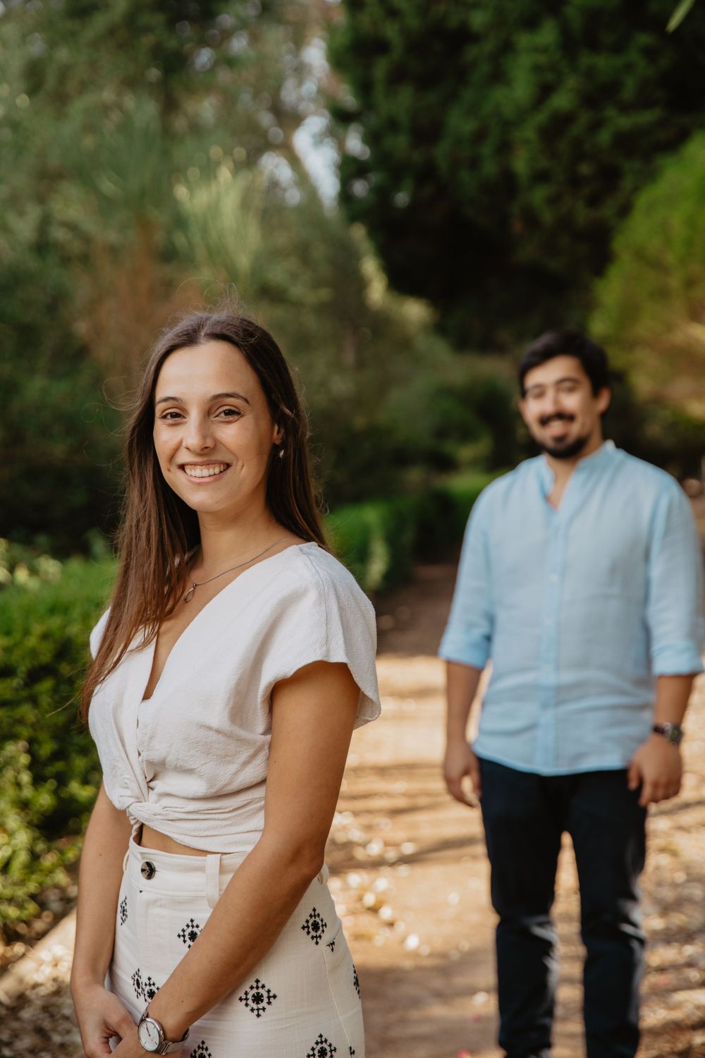 A romantic outdoor photoshoot with a couple in coordinated blue and white outfits.