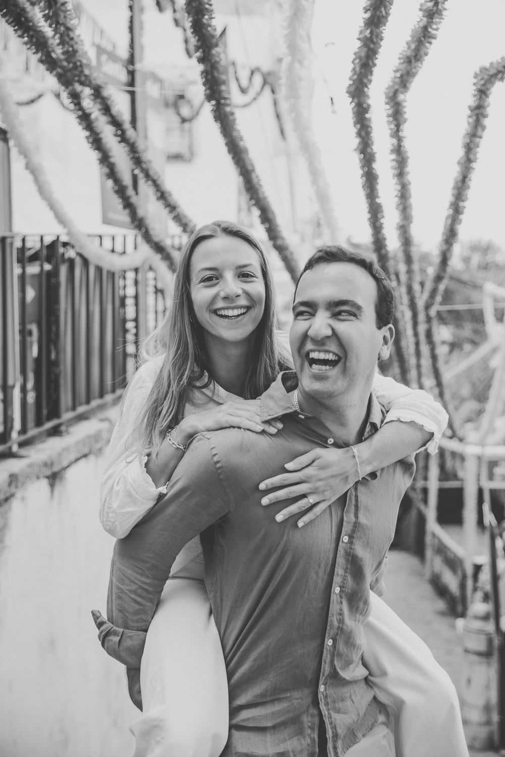 Black and white photographs showing candid laughter and embraces between two people.