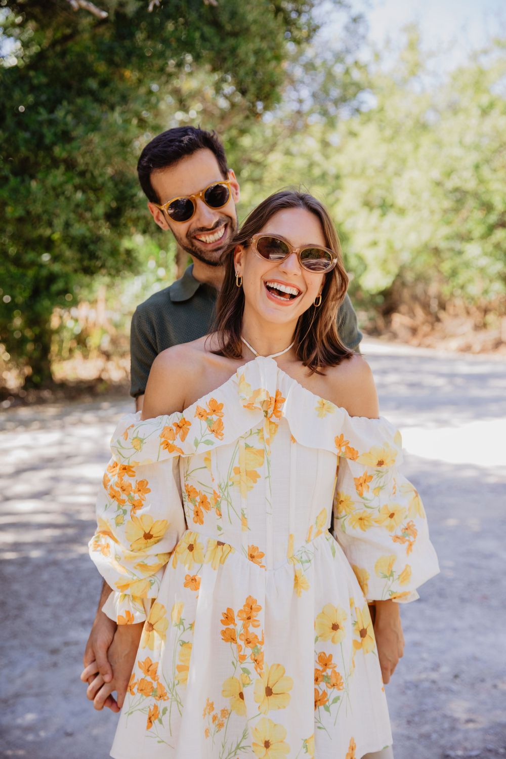Candid outdoor photoshoot with someone wearing a yellow floral dress in natural sunlight.