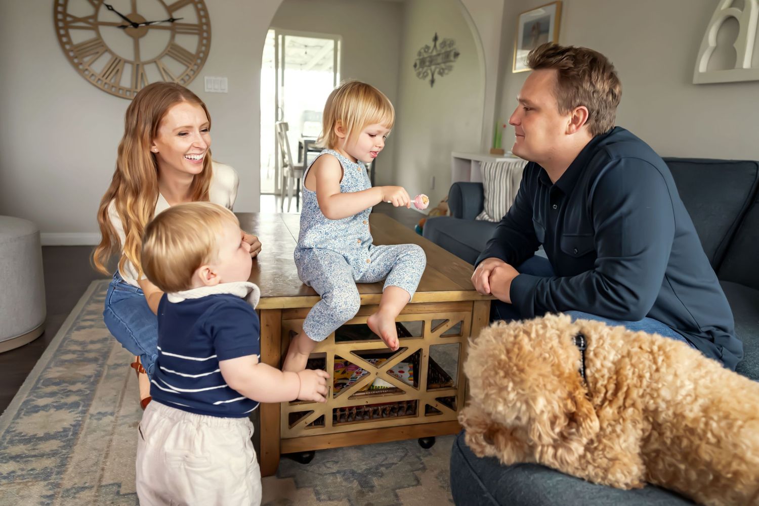 Kids sit on coffee table. Feed cake pop to dad. Doughman Photography.