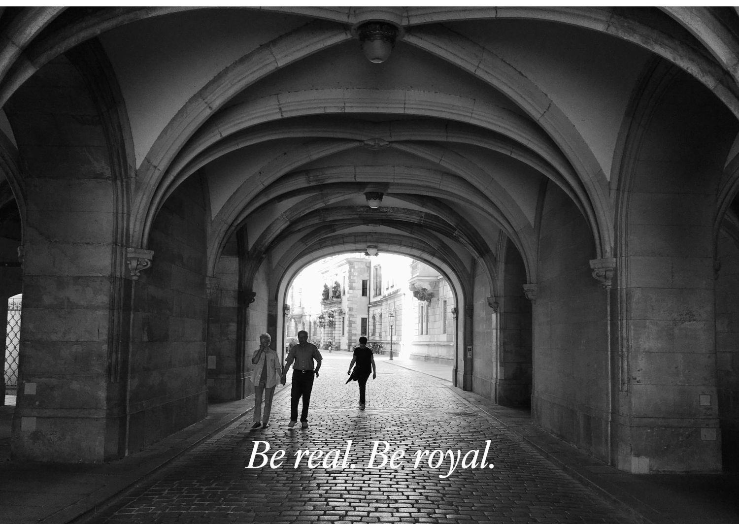 Silhouettes walking through gothic archway corridor with 'Be real. Be royal' text.