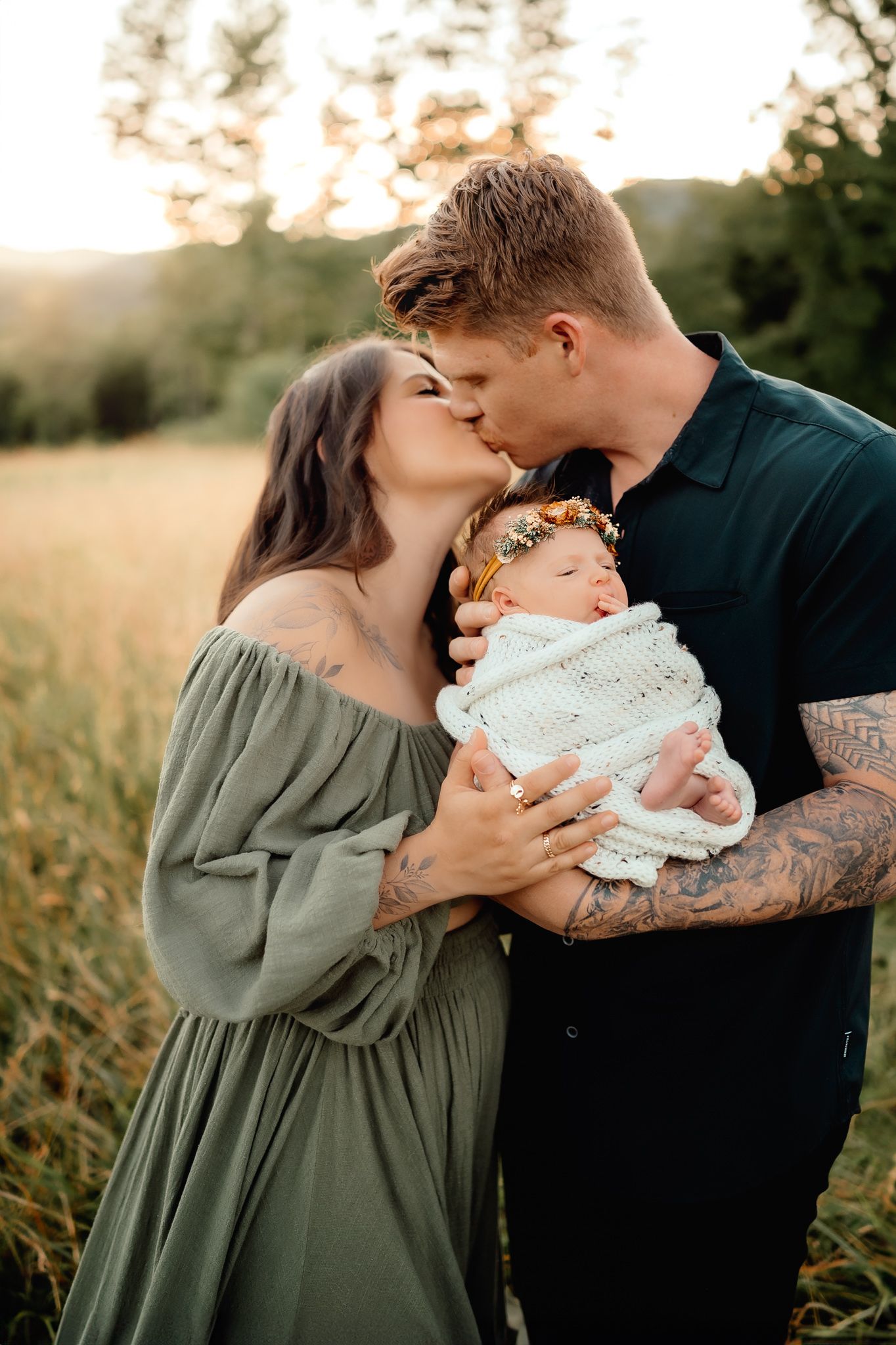 Intimate family portrait with newborn in golden evening light.