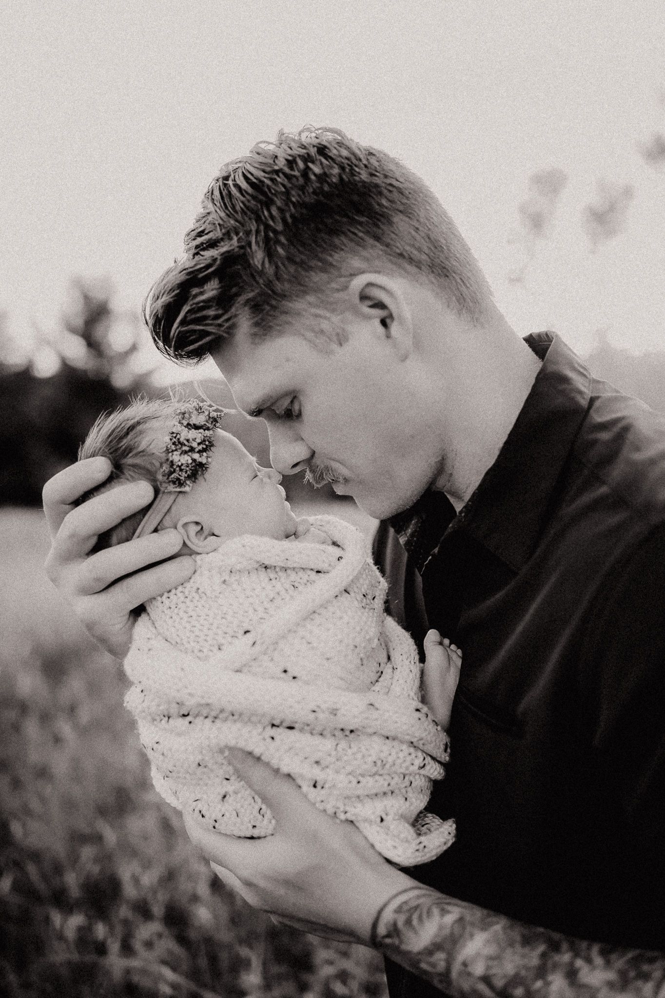 Black and white close-up of tender moment with sleeping newborn.