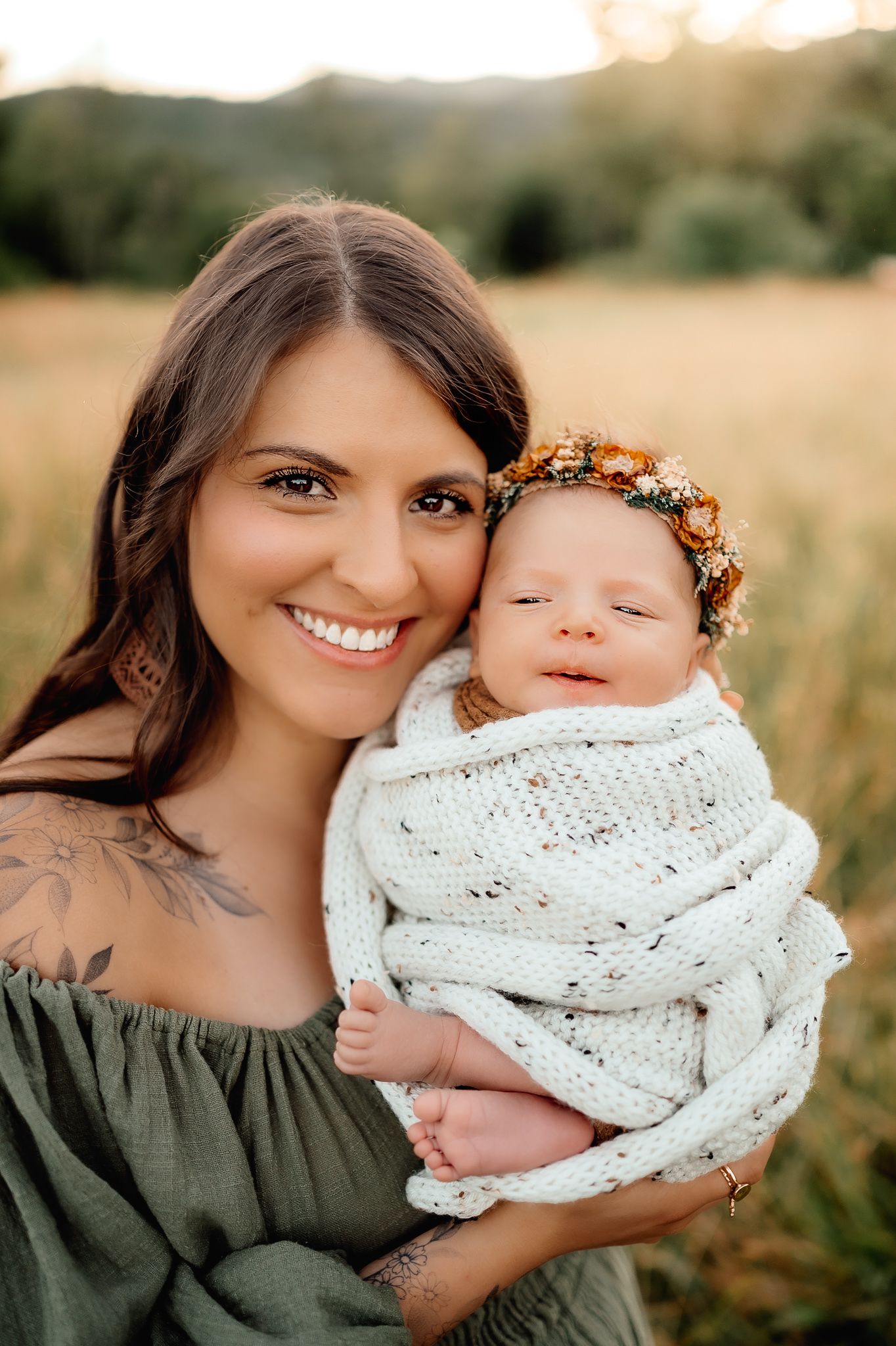 A tender outdoor family portrait in a summer meadow at golden hour.