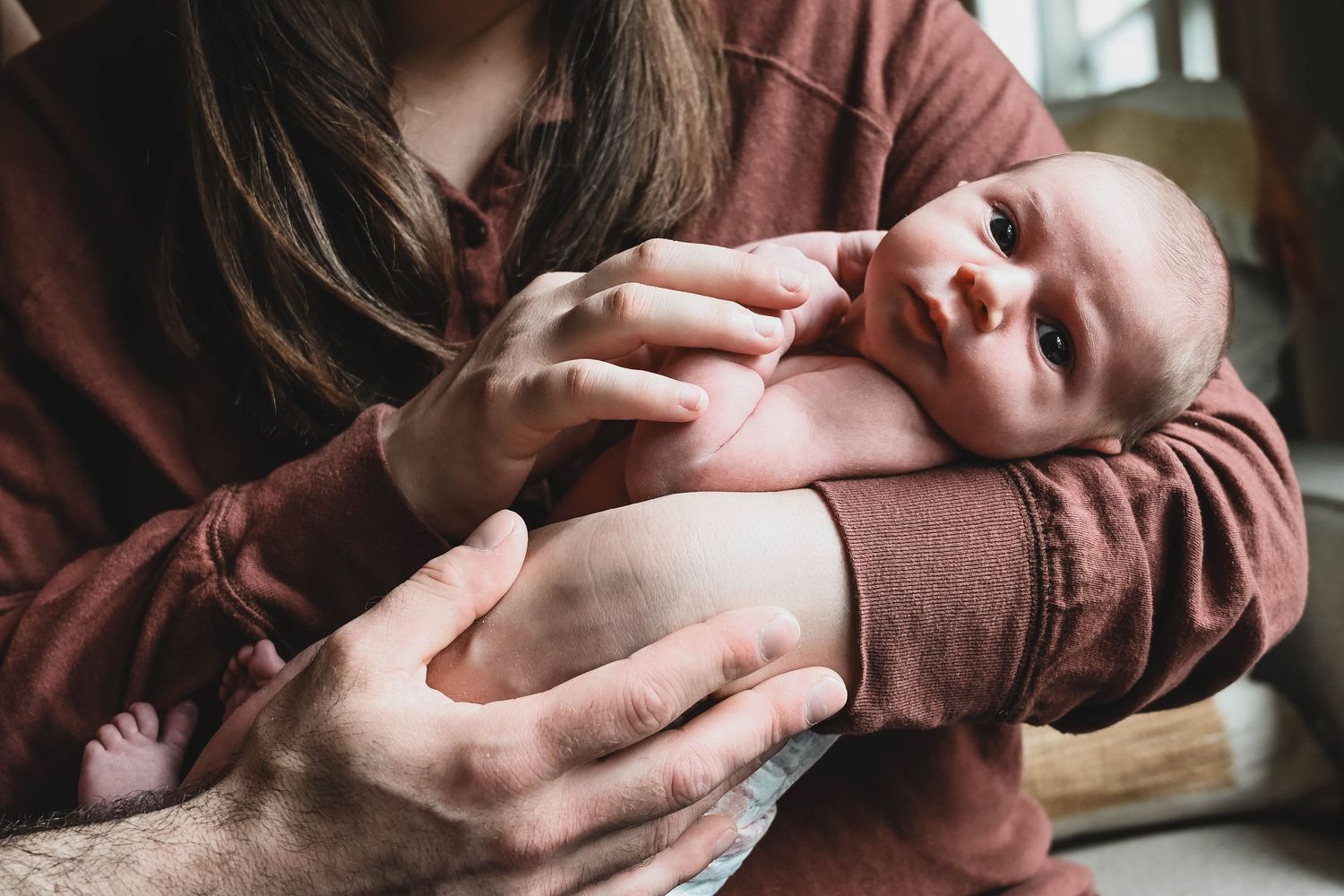 Newborn baby attentively looks at camera during lifestyle session near Albany, NY