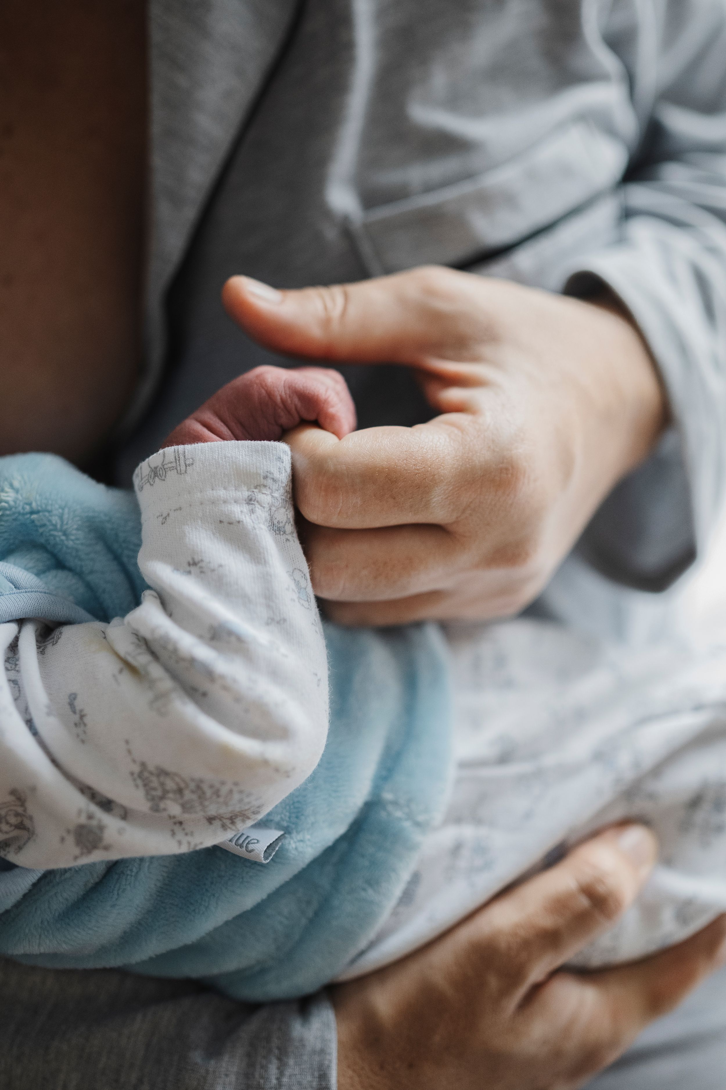 Mano de madre sosteniendo la de su bebé recién nacido en el sanatorio donde nació