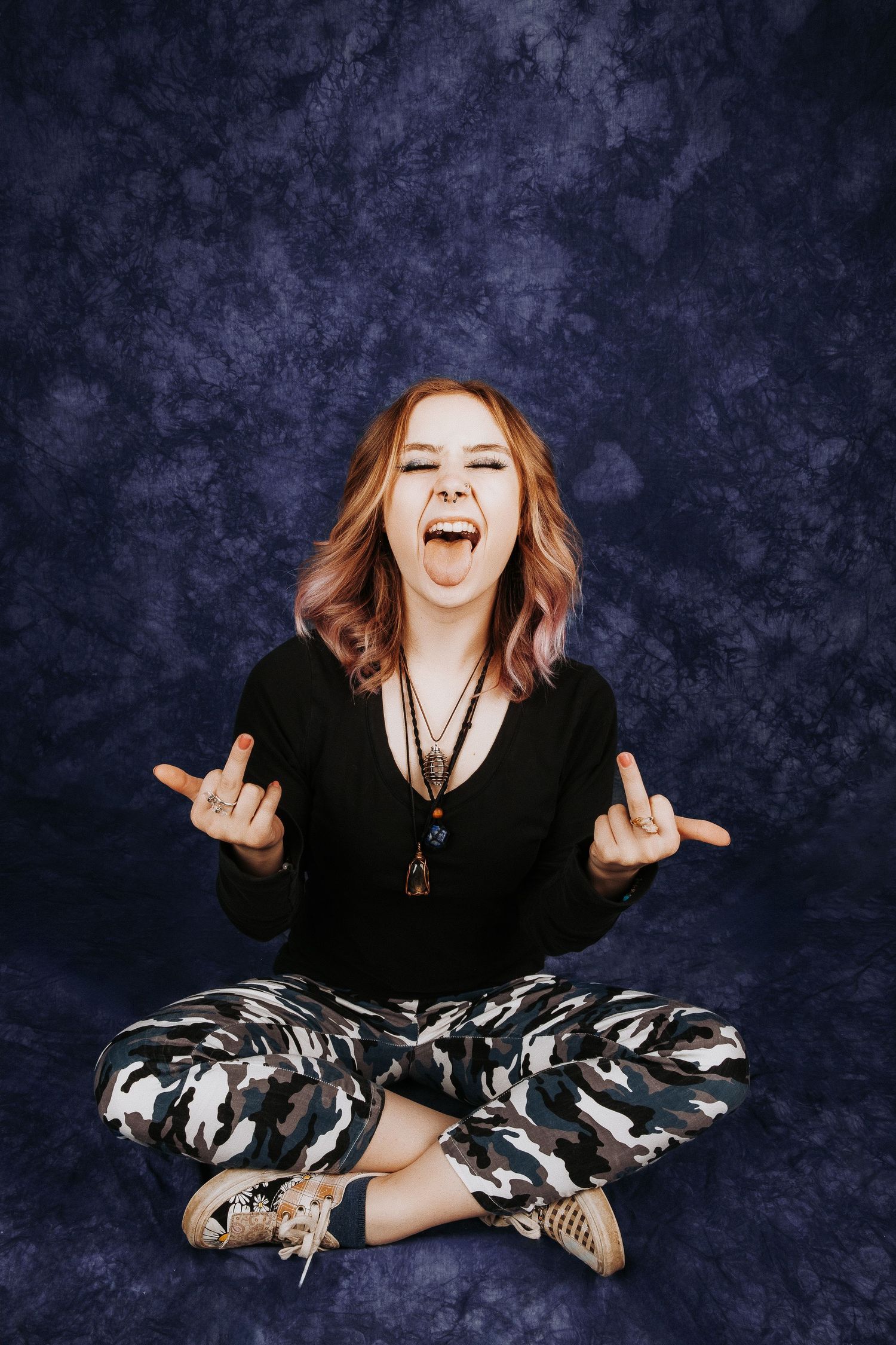 Energetic portrait series showing expressive poses in black outfit with camouflage pants.