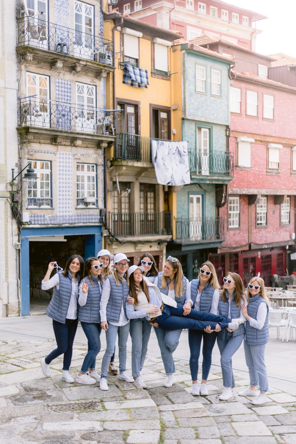 Sessão fotográfica fine art de despedida de solteira, grupo de raparigas na cidade do Porto com a noiva ao colo