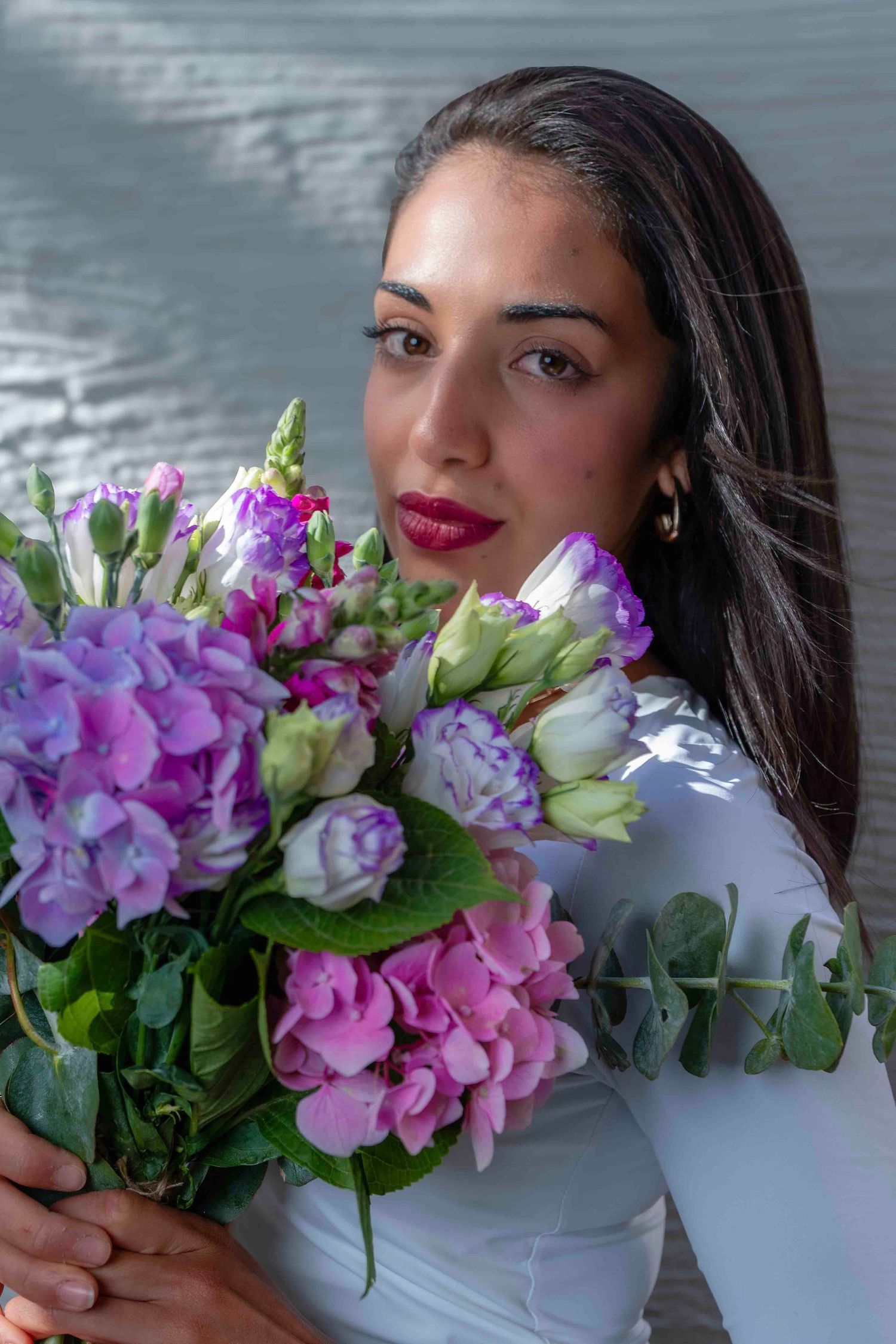 Ethereal portrait with red rose and flowing white fabric