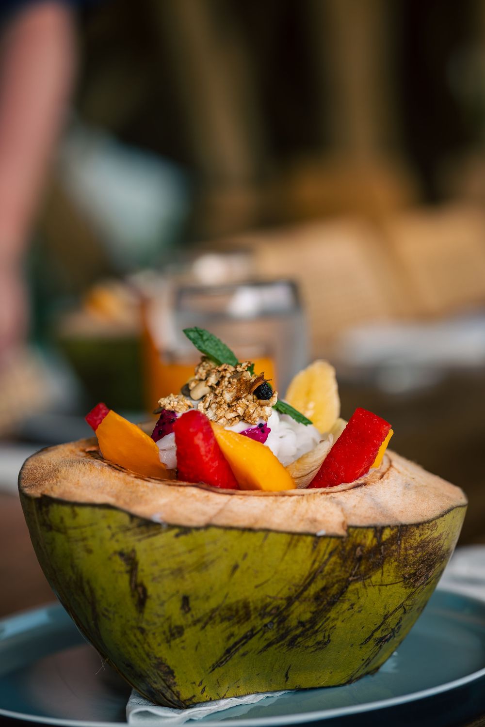 Colorful fruit and toppings served in fresh coconut shell bowls arranged in a stylish presentation.