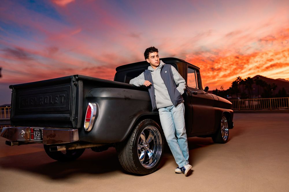 Tucson, AZ senior guy posing with his truck and a sunset