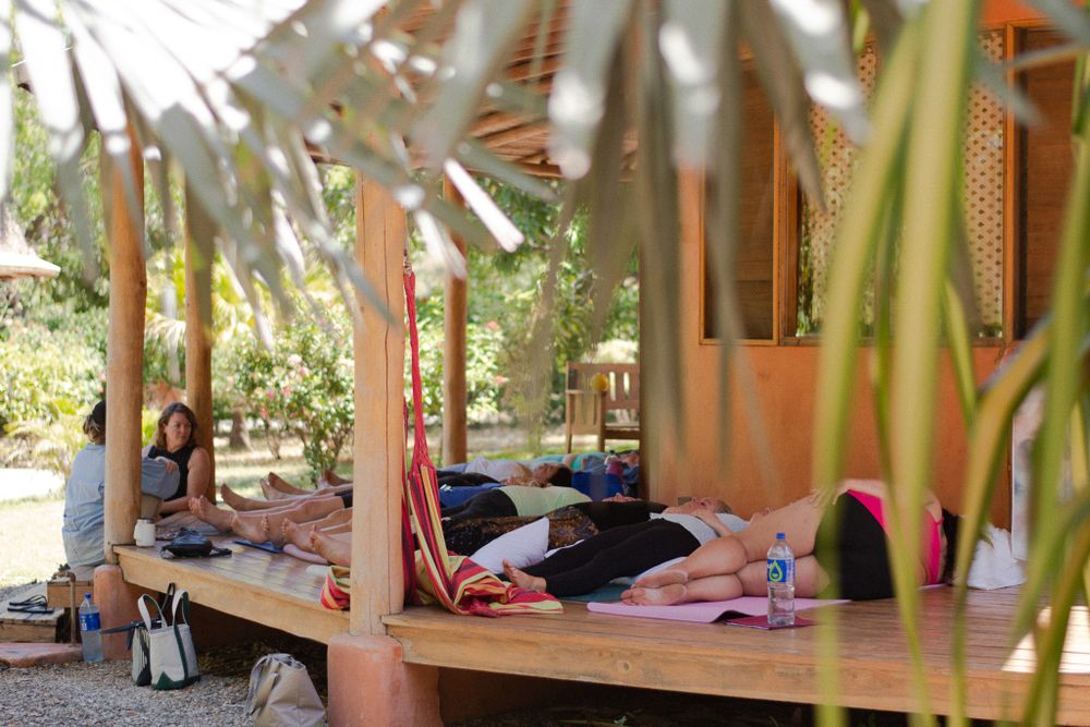 People resting on an outdoor covered platform during a wellness retreat.