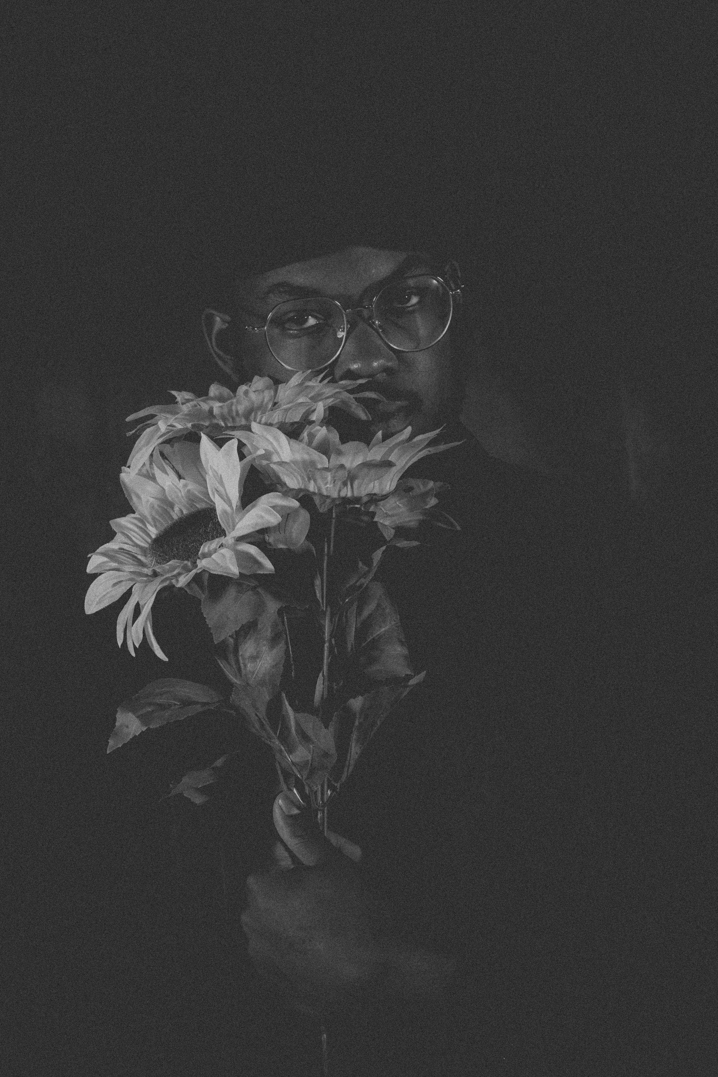 Artistic black and white photo sequence of white flowers against dark background.