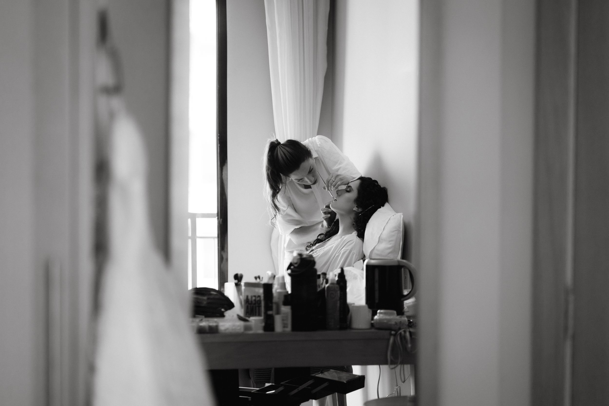 Black and white reflection in mirror showing preparation scene with flowing fabric.